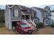 Two-story townhome with gray siding, attached garage, and a red SUV parked in the driveway at 390 Lakeridge Ct, Riverdale, GA 30274