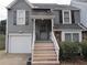 Charming two-story home with gray siding, attached garage, and inviting front entrance with stairs at 390 Lakeridge Ct, Riverdale, GA 30274