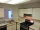 Functional kitchen featuring white cabinets and a gas range at 390 Lakeridge Ct, Riverdale, GA 30274