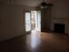 Bright living room featuring hardwood floors, fireplace, and glass doors leading to a balcony at 390 Lakeridge Ct, Riverdale, GA 30274