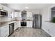 Modern kitchen with white cabinets, stainless steel appliances, and wood-look floors at 5768 Wesson Dr, Ellenwood, GA 30294