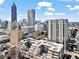 Aerial view of a modern city building complex with multiple buildings and city skyline in the background at 775 Juniper Ne St # 413, Atlanta, GA 30308
