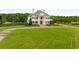 Aerial view of a grand home with a manicured lawn and pond at 833 Hines Rd, Moreland, GA 30259