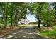 Long driveway leading to a beautiful home nestled among lush trees at 833 Hines Rd, Moreland, GA 30259