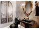 Stylish powder room with black vanity, ornate mirror, and unique wall decor at 833 Hines Rd, Moreland, GA 30259