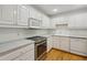 Well-lit kitchen with white cabinetry, stainless steel appliances, tile backsplash, and hardwood floors at 1634 Ponce De Leon Ne Ave # 514, Atlanta, GA 30307