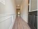 Inviting hallway with elegant wainscoting, crown molding, and durable wood-look flooring at 5435 Rock Place Ct # 38, Norcross, GA 30093