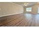 Spacious living room with hardwood floors, ceiling fan, and large window at 5435 Rock Place Ct # 38, Norcross, GA 30093