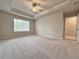 Spacious main bedroom with a ceiling fan, tray ceiling, and lots of natural light at 5435 Rock Place Ct # 38, Norcross, GA 30093