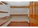 Walk-in closet featuring multiple shelves, hardwood floors, and a door at 850 Thurman Rd, Stockbridge, GA 30281