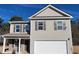 Two-story house with gray siding, brick accents, and a white garage door at 140 Tye St, Stockbridge, GA 30281