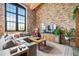 Living room with exposed brick, sectional sofa, and large window at 170 Boulevard Se # H401, Atlanta, GA 30312