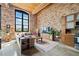 Open living area with exposed brick, kitchen, and large windows at 170 Boulevard Se # H401, Atlanta, GA 30312