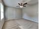 Well-lit bedroom with ceiling fan and double-door closet at 532 Greg Sw Dr, Lilburn, GA 30047