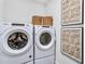 Laundry room with Whirlpool washer and dryer, stylish baskets, and artwork at 5395 Julep Ct, Cumming, GA 30028