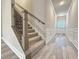 Hallway with gray floors, paneled trim, and stairway with carpeted steps and wrought iron balusters at 5455 Rock Place Ct # 40, Norcross, GA 30093