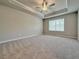 Spacious main bedroom featuring tray ceiling, neutral carpet, and large window at 5455 Rock Place Ct # 40, Norcross, GA 30093