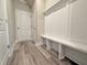 Functional mudroom featuring stylish gray floors, board and batten, bench, and two doors at 5455 Rock Place Ct # 40, Norcross, GA 30093