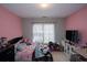 Bright bedroom featuring pink walls, a cozy bed, and a window with natural light at 2353 Maplewood Se Ct # 25, Atlanta, GA 30339