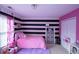 Bright bedroom with striped accent wall, plush pink bed, and cozy window seat at 2353 Maplewood Se Ct # 25, Atlanta, GA 30339