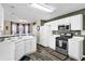 Bright kitchen with white cabinets, stainless steel appliances, and wood-look flooring at 3945 Brushy Creek Way, Suwanee, GA 30024