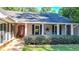 Gray house with red front door, white columns, and lush landscaping at 4692 Yeager Rd, Douglasville, GA 30135