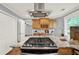 Modern kitchen island with cooktop and stainless steel range hood at 4692 Yeager Rd, Douglasville, GA 30135