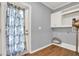 Bright laundry room with wood floors, built-in cabinets, and exterior access at 4692 Yeager Rd, Douglasville, GA 30135