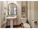 Stylish powder room with pedestal sink, vertical striped wallpaper and decorative mirror at 1103 Ridenour Ct, Kennesaw, GA 30152