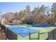 Two well-maintained tennis courts with surrounding fencing, in a wooded setting at 1103 Ridenour Ct, Kennesaw, GA 30152