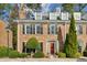 Brick townhouse with a red door, landscaping, and dormer windows at 15 Independence Nw Pl, Atlanta, GA 30318