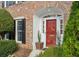 Red front door entryway with brick facade and potted plants at 15 Independence Nw Pl, Atlanta, GA 30318