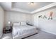 Spacious main bedroom featuring tray ceiling and carpeted floors, bathed in natural light at 150 Auburn Depot Dr, Auburn, GA 30011