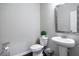 Small powder room with pedestal sink and mirror at 150 Auburn Depot Dr, Auburn, GA 30011