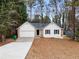 White house with stone accents, attached garage, and a yard at 2966 Knollberry Ln, Decatur, GA 30034