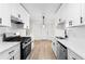 Bright kitchen with white cabinets, stainless steel appliances, and luxury vinyl plank flooring at 2966 Knollberry Ln, Decatur, GA 30034