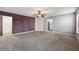 Bright living room with grey and purple walls, and carpeted floors at 527 Mossycup Dr, Fairburn, GA 30213