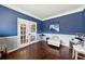 Office features hardwood floors, French doors, and blue walls at 527 Mossycup Dr, Fairburn, GA 30213