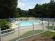 Community swimming pool with surrounding lounge chairs and fence at 170 Amicalola Way, Jonesboro, GA 30236