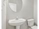 Small bathroom with pedestal sink and toilet at 2297 Elmbridge Rd, Buford, GA 30519