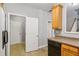 Kitchen with a view into hallway, oak cabinets and black dishwasher at 2297 Elmbridge Rd, Buford, GA 30519