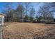 Large, fenced in backyard with mature trees and a fire pit at 2210 Burdett Ridge, Atlanta, GA 30349