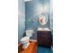 Powder room with dark vanity, oval mirror and blue walls at 679 Crosswinds Cir, Marietta, GA 30008