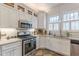 Bright kitchen featuring white cabinetry, stainless steel appliances, and granite countertops at 1736 Thompson Ave, Atlanta, GA 30344