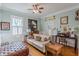 Comfortable living room features lots of natural light, vintage artwork, and a ceiling fan at 1736 Thompson Ave, Atlanta, GA 30344