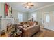 Bright living room with a brick fireplace, hardwood floors, and an entry door at 1736 Thompson Ave, Atlanta, GA 30344