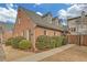 Charming brick home featuring dormer windows, mature landscaping, and a walkway leading to the entrance at 218 Forkner Dr # D, Decatur, GA 30030