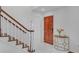 Bright foyer with a staircase, hardwood door, table, and white tile flooring at 218 Forkner Dr # D, Decatur, GA 30030