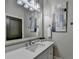 Bathroom featuring single vanity with granite counters, framed mirror, and decorative light fixture at 5890 Bond St, Cumming, GA 30040