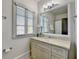 Well-lit bathroom featuring a vanity with storage, mirror, and an adjacent bathtub at 5890 Bond St, Cumming, GA 30040